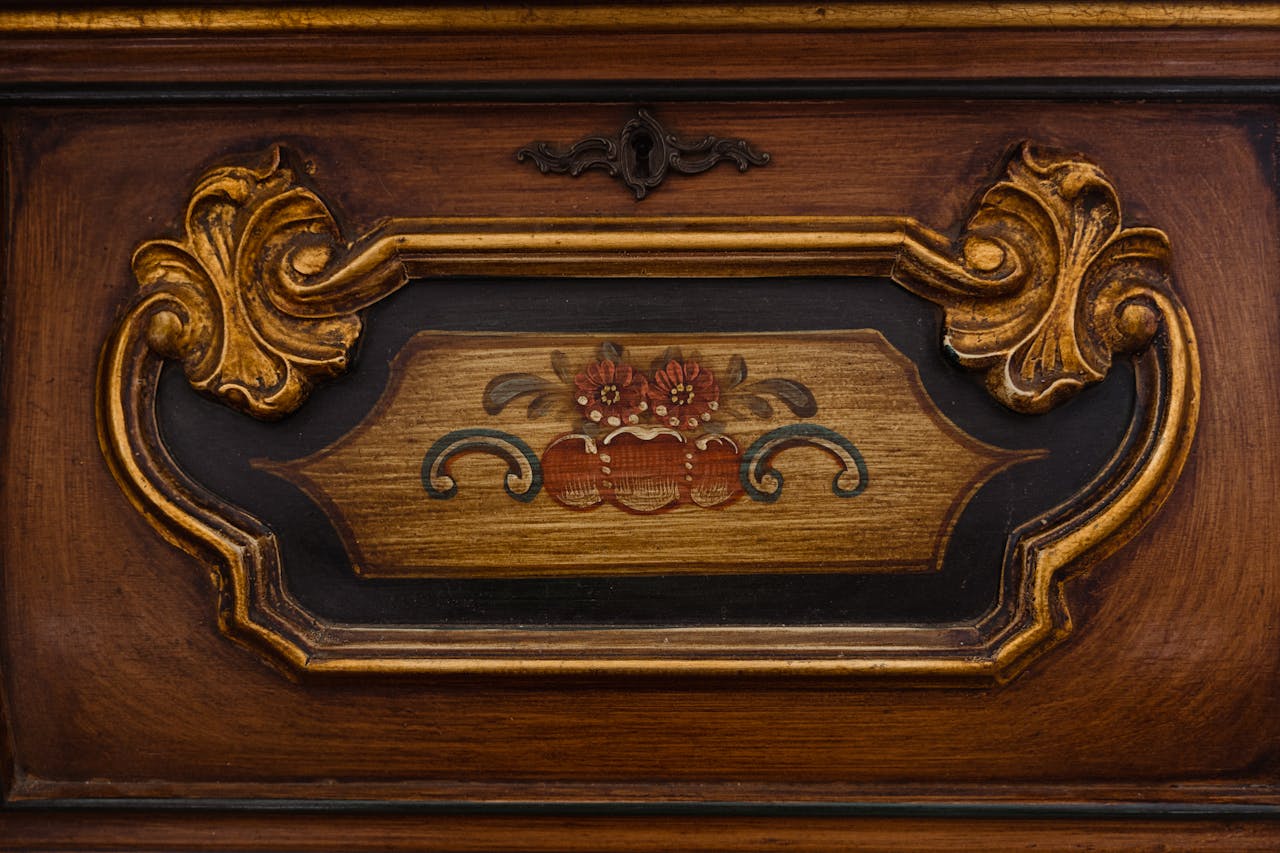 Close-up of antique wooden furniture with intricate carved design and vintage floral art.